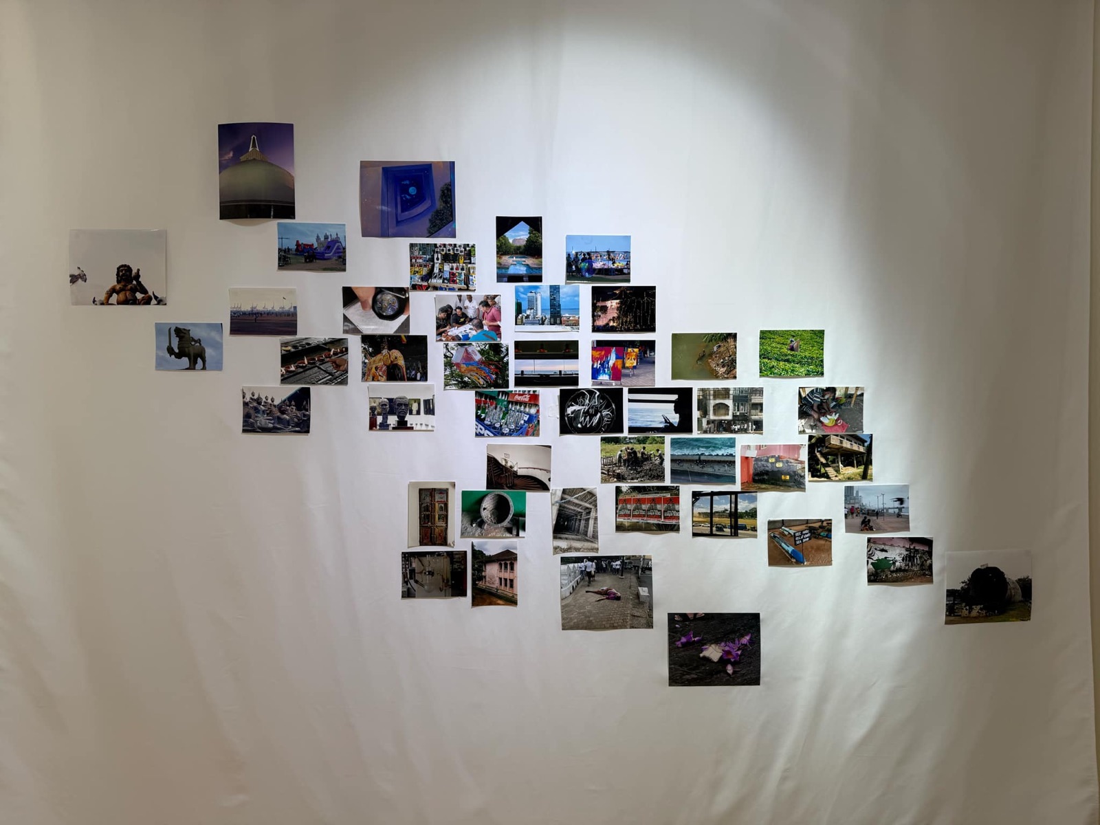 Daisaku Hashizume&rsquo;s composition: photographs of statues, temples, streets and the sea on a white cloth