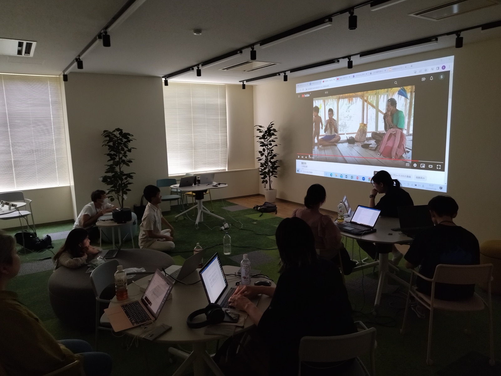 A workshop review session: participants watch an edited film projected on the wall